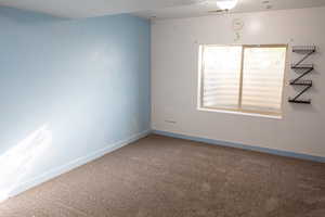Carpeted empty room featuring baseboards