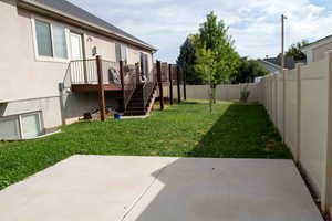 Fenced backyard with stairs, a patio area, and a deck