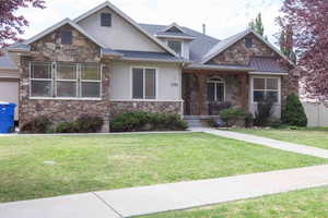 View of front of house featuring stone siding, stucco siding, and a porch