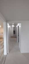 Hallway featuring baseboards and light tile patterned floors