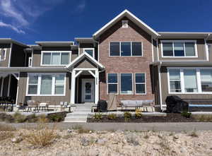 Front of home featuring an outdoor hangout area, board and batten siding, and brick siding
