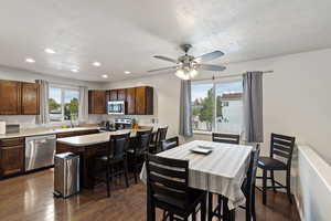 Dining room with dark wood-style flooring, recessed lighting, a ceiling fan, and a textured ceiling