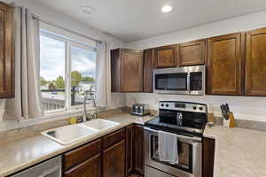 Kitchen with stainless steel appliances, light countertops, and recessed lighting