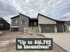 View of front of property with a garage and concrete driveway