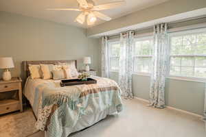 Carpeted bedroom with baseboards and a ceiling fan