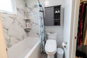 Full bath with shower / tub combo with curtain and toilet