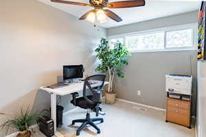 Office area with light carpet and ceiling fan