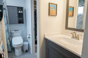 Bathroom featuring vanity, light tile patterned floors, and curtained shower