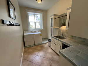 Laundry area featuring light tile patterned floors and washer and dryer