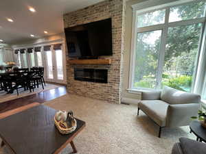 Living room featuring recessed lighting, french doors, a brick fireplace, and carpet floors