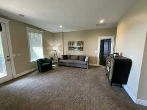 Living area featuring dark carpet and recessed lighting