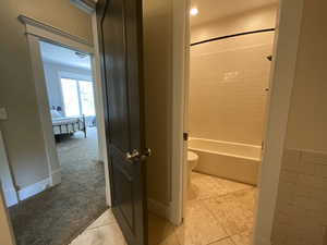 Full bath featuring bathtub / shower combination and light tile patterned floors