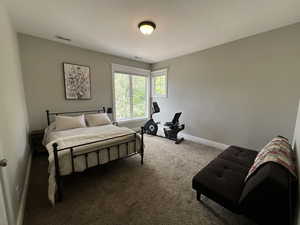Bedroom featuring carpet and baseboards