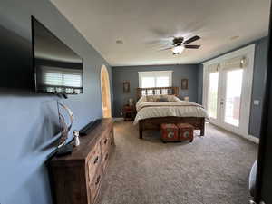 Carpeted bedroom featuring access to exterior and ceiling fan