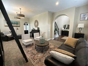 Living area with arched walkways, stairway, and recessed lighting