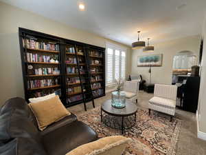 Sitting room featuring arched walkways, carpet, and recessed lighting