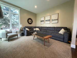 Carpeted living area with recessed lighting and baseboards