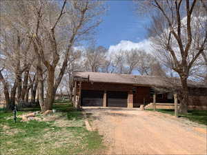 View of front of property featuring driveway, an attached garage, and brick siding