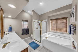 Bathroom featuring light tile patterned flooring, double vanity, a garden tub, a stall shower, and recessed lighting