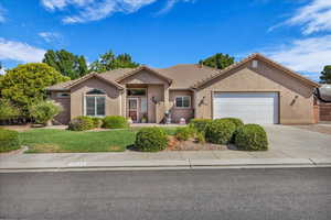 Ranch-style home featuring driveway, stucco siding, a garage, a front lawn, and a tile roof
