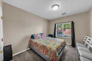Bedroom with carpet and a textured ceiling