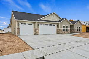 Craftsman house featuring a garage, stone siding, concrete driveway, and a shingled roof