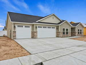 Craftsman house featuring a garage, stone siding, concrete driveway, and a shingled roof