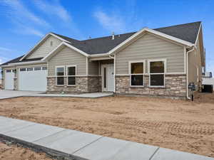 Craftsman house featuring stone siding, driveway, an attached garage, and roof with shingles