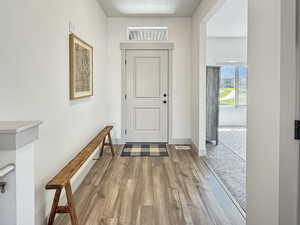 Entryway with wood finished floors and baseboards