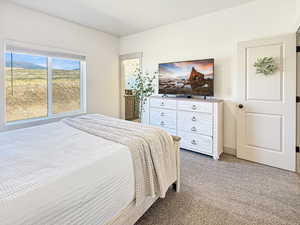 Bedroom featuring light colored carpet and ensuite bath