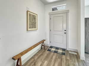 Entryway with light wood finished floors and baseboards