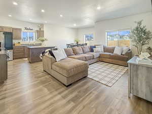 Living area with a textured ceiling, recessed lighting, light wood-type flooring, and plenty of natural light