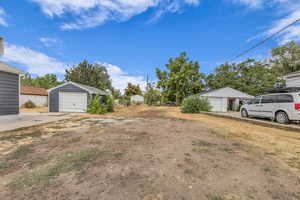 View of yard with a garage and an outdoor structure