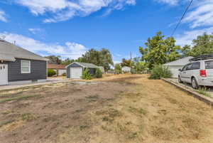 View of yard with a garage and an outbuilding
