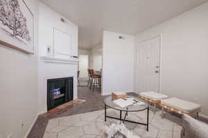 Living room with light colored carpet and a fireplace with flush hearth