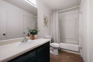 Bathroom featuring shower / bath combo, dark wood finished floors, and vanity