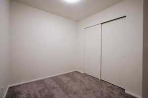 Unfurnished bedroom with carpet flooring and a closet