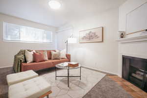 Tiled living area with a fireplace with flush hearth and baseboards