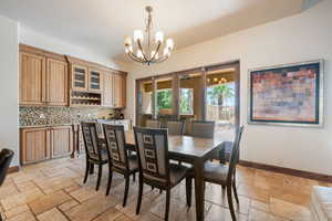 Dining space with stone tile floors and a chandelier