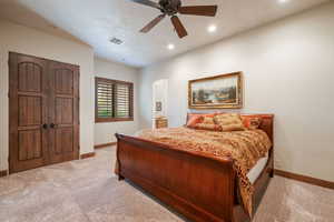 Bedroom featuring light carpet, recessed lighting, a ceiling fan, ensuite bath, and a closet