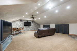Cinema room with light colored carpet, vaulted ceiling, and recessed lighting