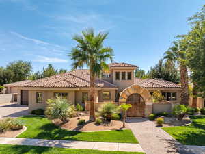 Mediterranean / spanish-style house with stucco siding, a gate, and a tiled roof