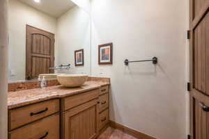 Half bathroom featuring vanity and light tile patterned floors
