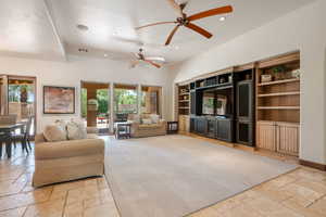 Living room featuring stone tile flooring, recessed lighting, and a ceiling fan
