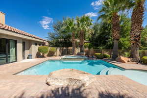 View of pool featuring a patio area, a fenced backyard, and a pool with connected hot tub