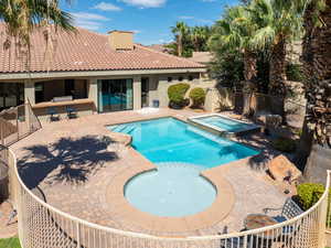 View of swimming pool with a patio area, a fenced backyard, and a pool with connected hot tub