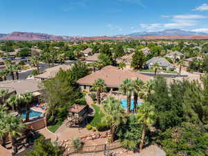 Aerial perspective of suburban area featuring a pool and a mountainous background