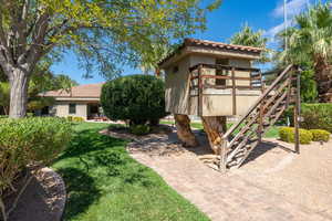 Exterior space with stairway, a front lawn, stucco siding, and a tiled roof