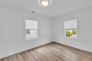Unfurnished room with light wood-style flooring and baseboards