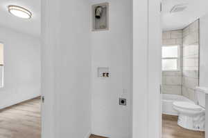 Laundry room with light wood-style floors, hookup for a washing machine, and electric dryer hookup